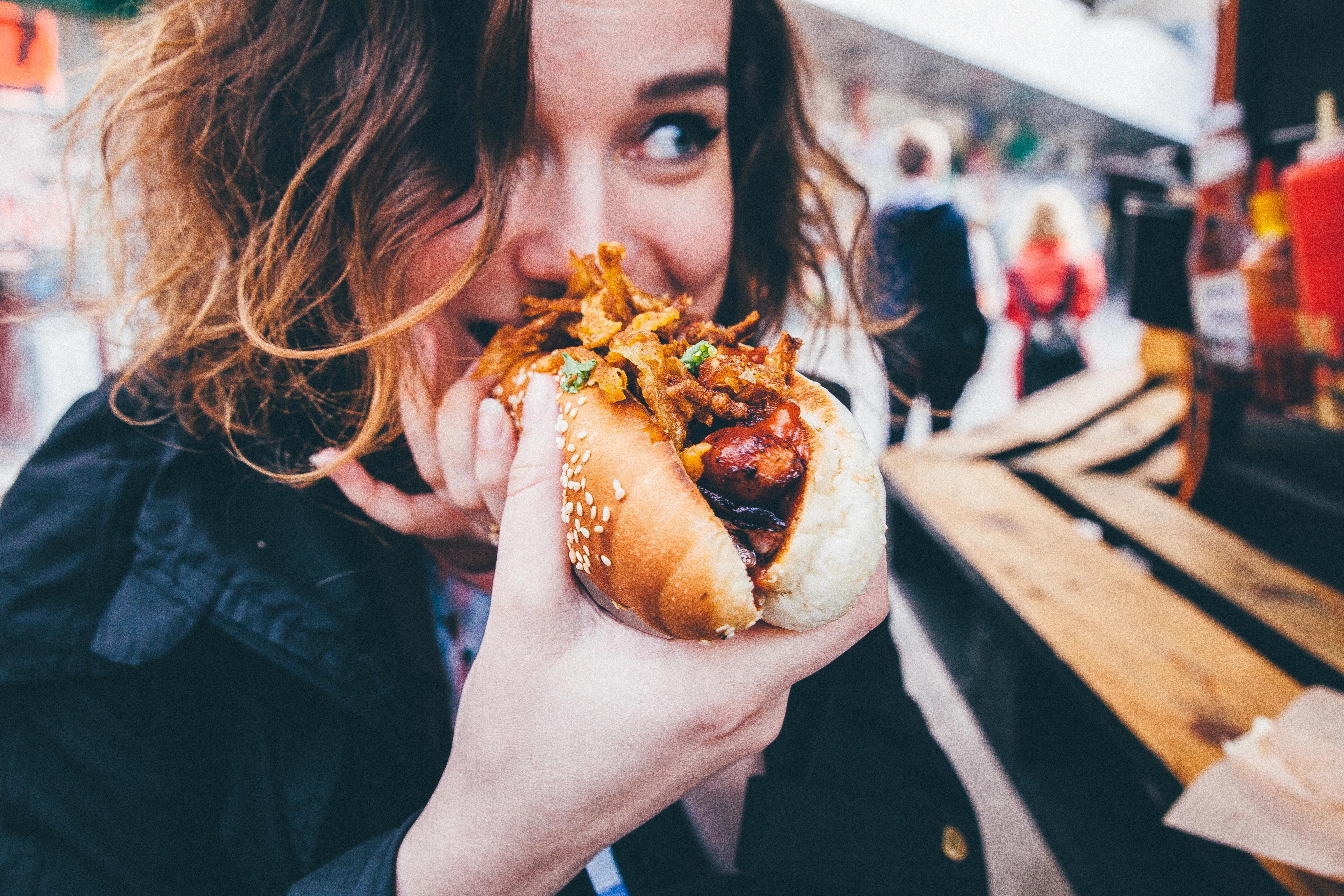 Rozkrojený burger na dřevěném prkénku s hranolkami