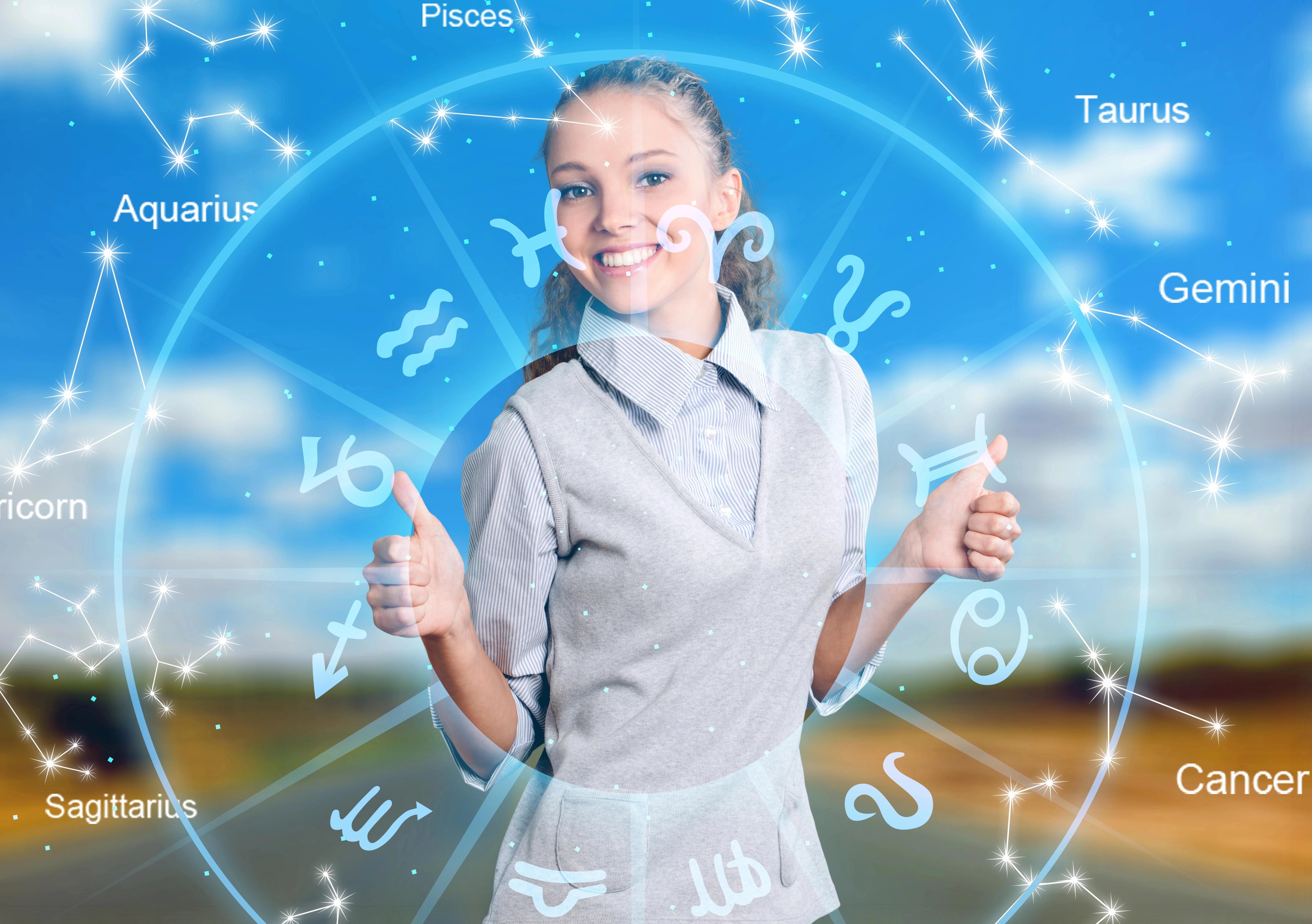 Usměvavá žena obklopená astrologickými symboly znamení zvěrokruhu.