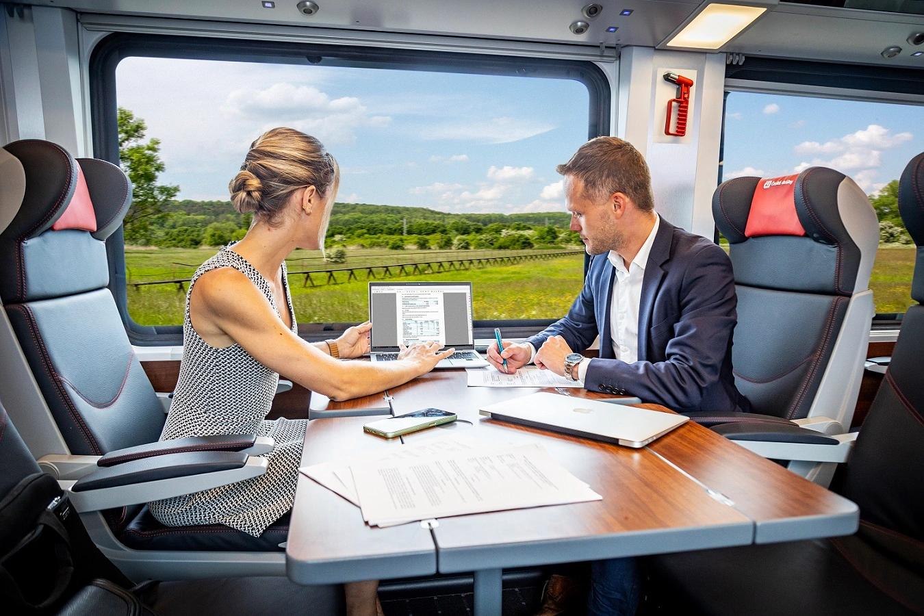 Moderní interiér první třídy ve vlaku ComfortJet s dvěma lidmi u stolu