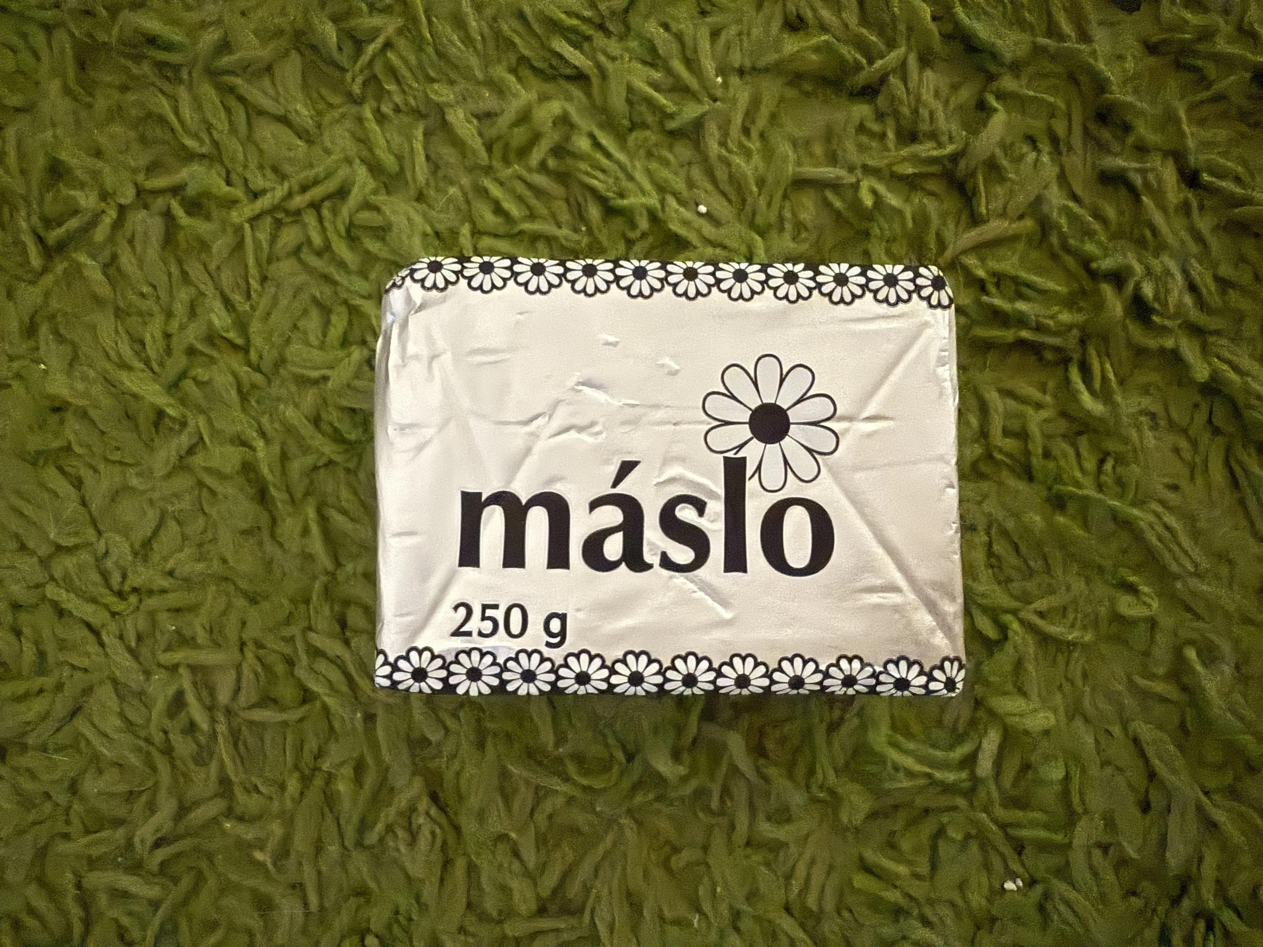 Otevřený balíček másla s viditelnou texturou