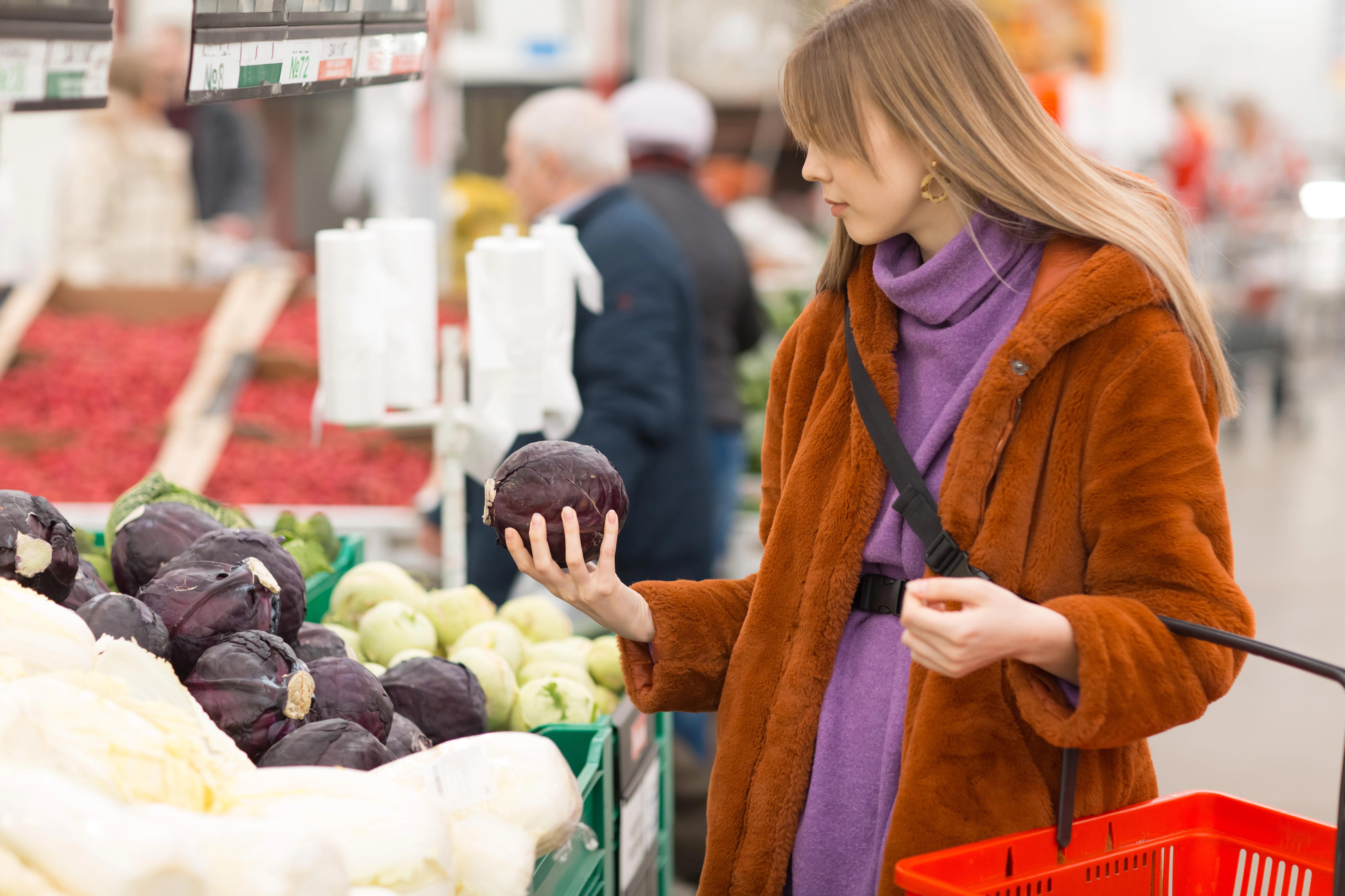 Žena držící slevové kupóny v supermarketu