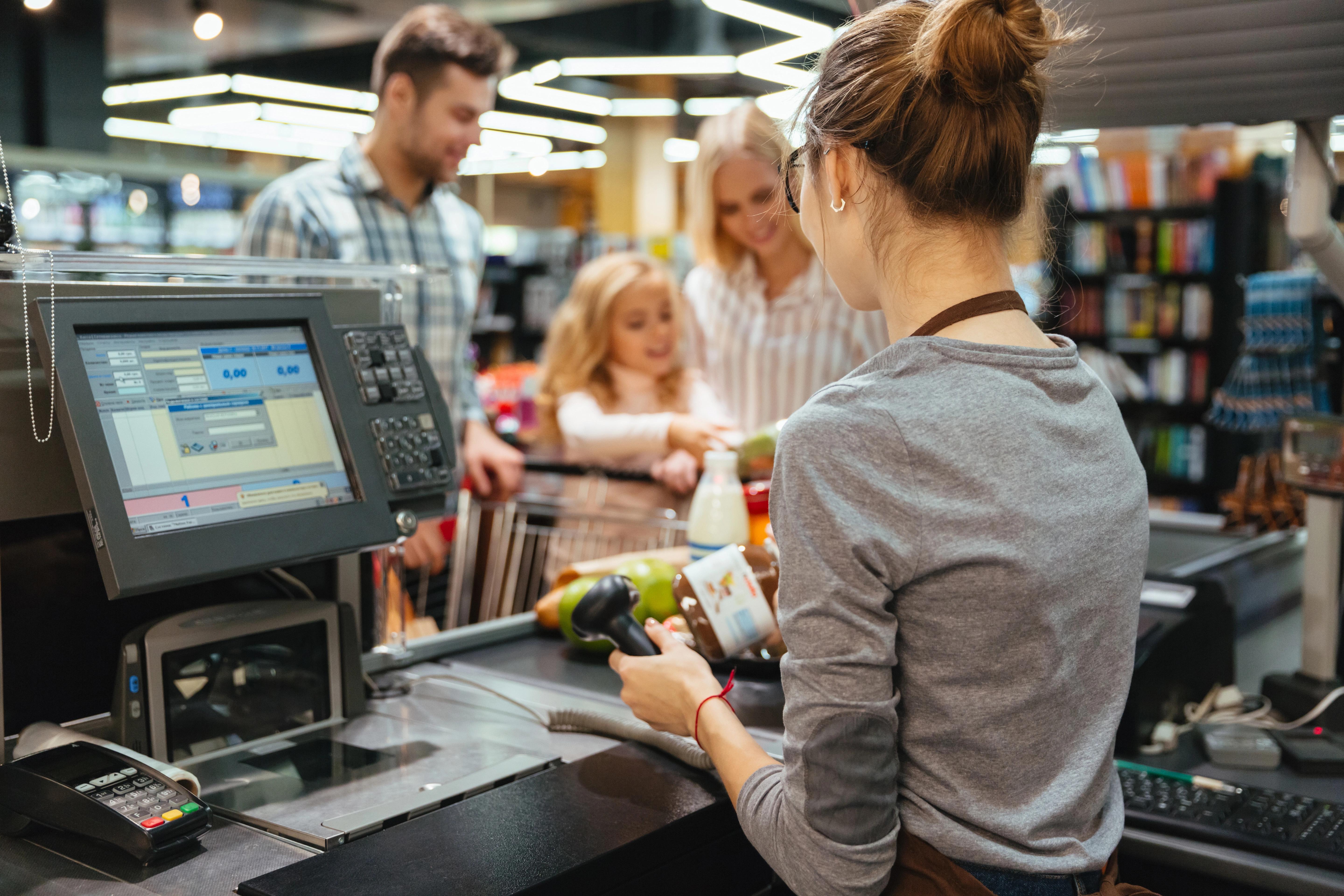 Lidé stojící ve frontě u pokladny v supermarketu